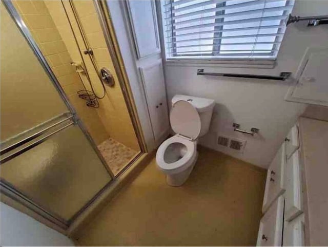 bathroom with toilet and a shower with shower door