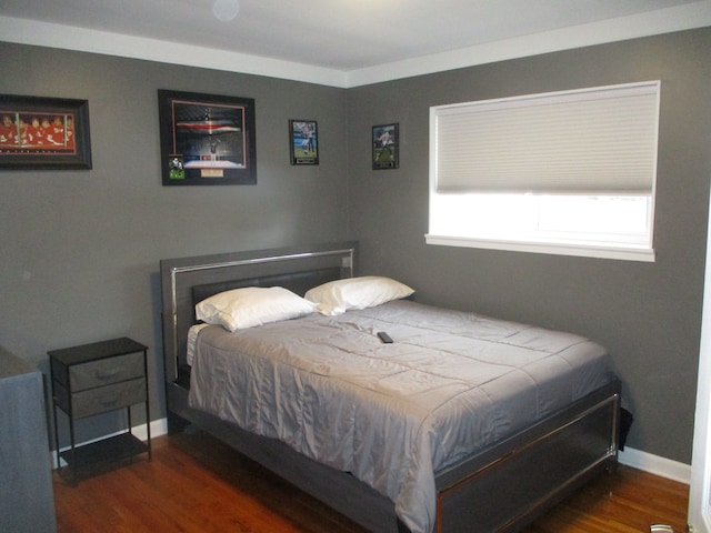 bedroom with dark wood-type flooring and ornamental molding