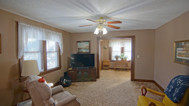 living room featuring a textured ceiling, carpet floors, and ceiling fan