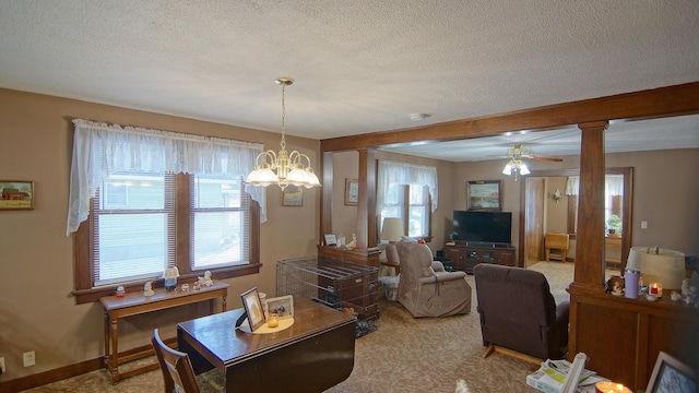 carpeted dining space featuring ceiling fan with notable chandelier, a textured ceiling, and ornate columns