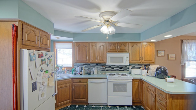 kitchen with sink, white appliances, ceiling fan, backsplash, and kitchen peninsula