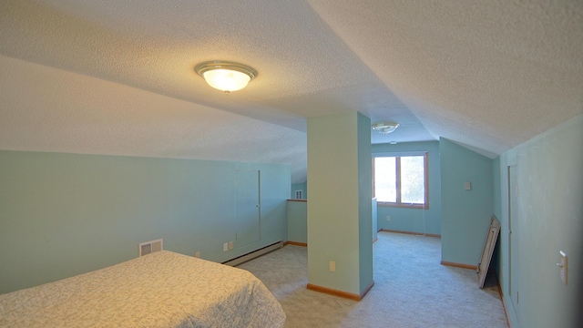 bedroom featuring lofted ceiling, a textured ceiling, light carpet, and a baseboard heating unit