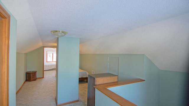 bonus room featuring light carpet, vaulted ceiling, and a textured ceiling