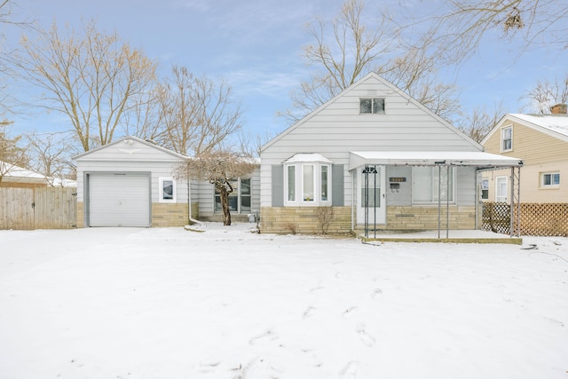 snow covered house featuring a garage and an outdoor structure