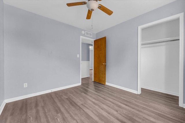 unfurnished bedroom with hardwood / wood-style flooring, a closet, and ceiling fan