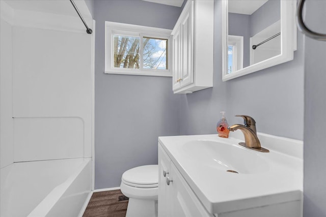 full bathroom featuring hardwood / wood-style flooring, vanity, shower / tub combination, and toilet