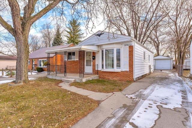 bungalow with a garage, an outbuilding, and a front lawn