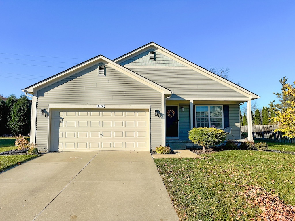 single story home featuring a garage and a front yard