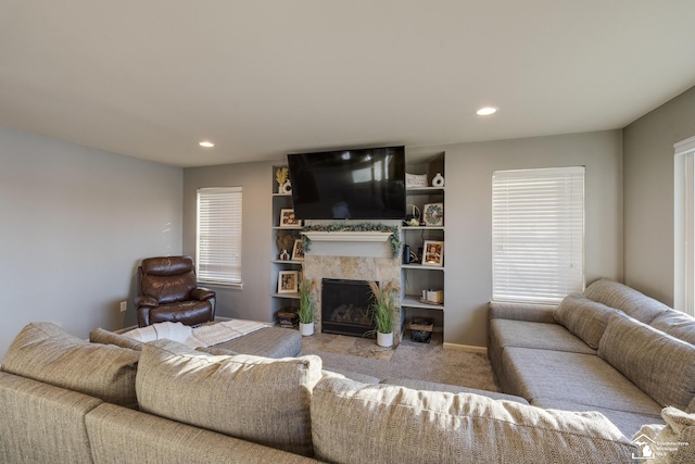 carpeted living room with a tile fireplace