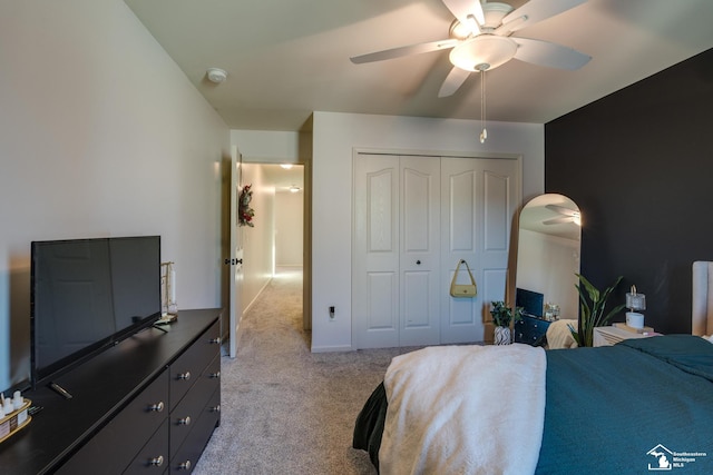 bedroom featuring ceiling fan, light carpet, and a closet