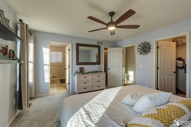 bedroom featuring ensuite bath, ceiling fan, a spacious closet, light colored carpet, and a closet