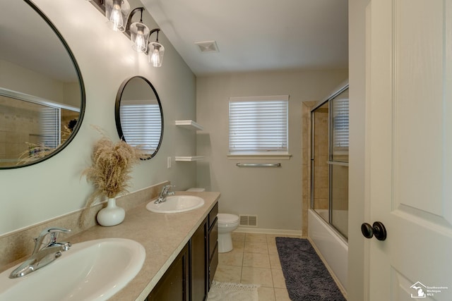 full bathroom with bath / shower combo with glass door, vanity, toilet, and tile patterned flooring