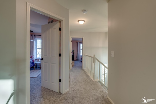 hall with light colored carpet