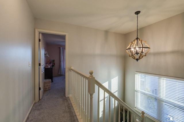 hall featuring a notable chandelier and carpet flooring