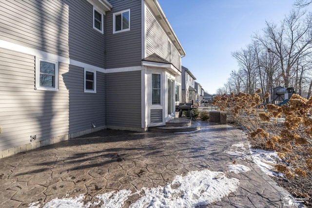 snow covered property featuring a patio area