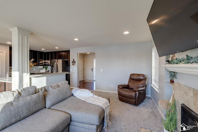 living room featuring light colored carpet and a fireplace