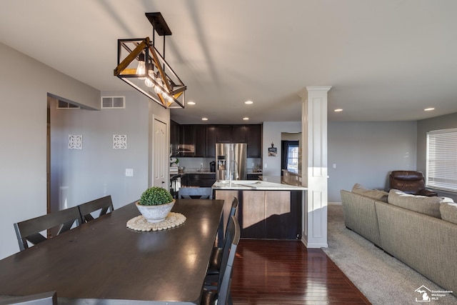 dining room featuring dark hardwood / wood-style floors and ornate columns