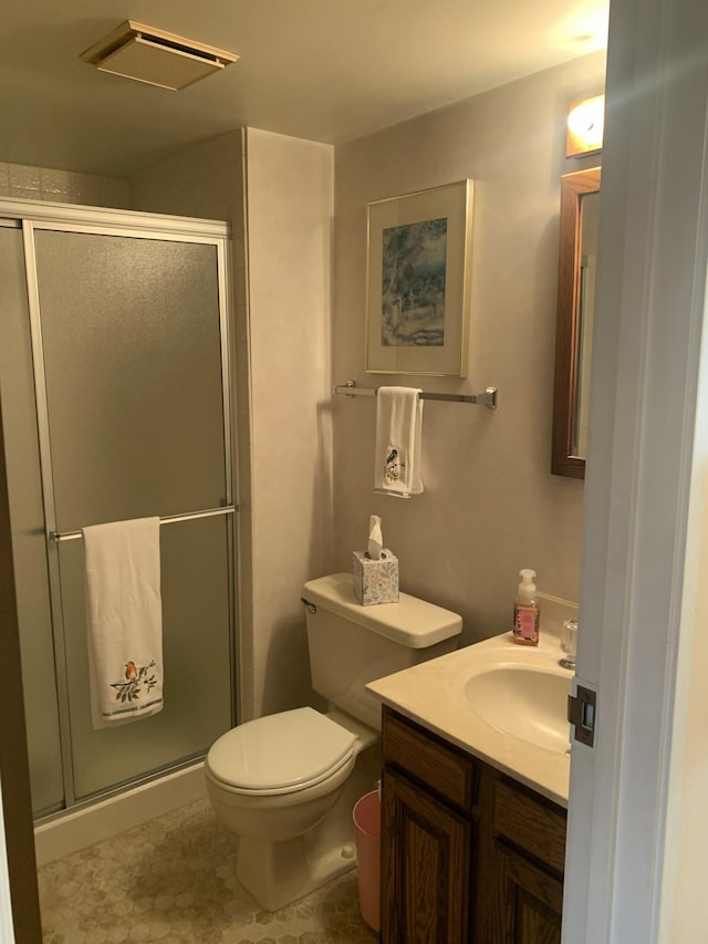 bathroom with vanity, a shower with shower door, and toilet