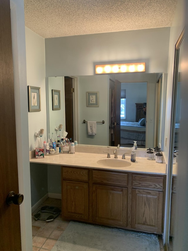 bathroom featuring tile patterned floors, vanity, and a textured ceiling