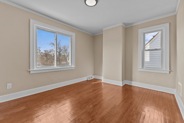 spare room with ornamental molding and hardwood / wood-style floors