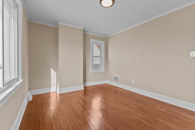 unfurnished room featuring crown molding, wood-type flooring, and a healthy amount of sunlight