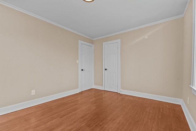 empty room featuring hardwood / wood-style flooring and crown molding