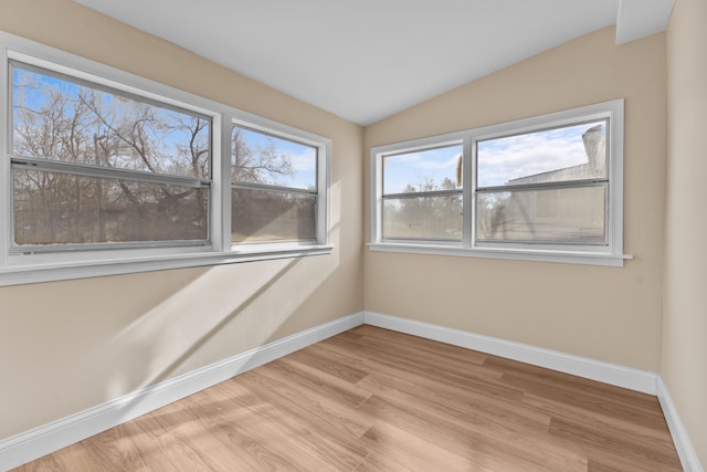 unfurnished room with vaulted ceiling and light hardwood / wood-style flooring