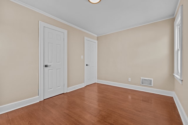 empty room featuring crown molding and hardwood / wood-style flooring