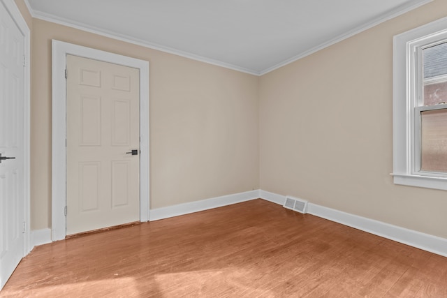 empty room featuring ornamental molding and hardwood / wood-style floors