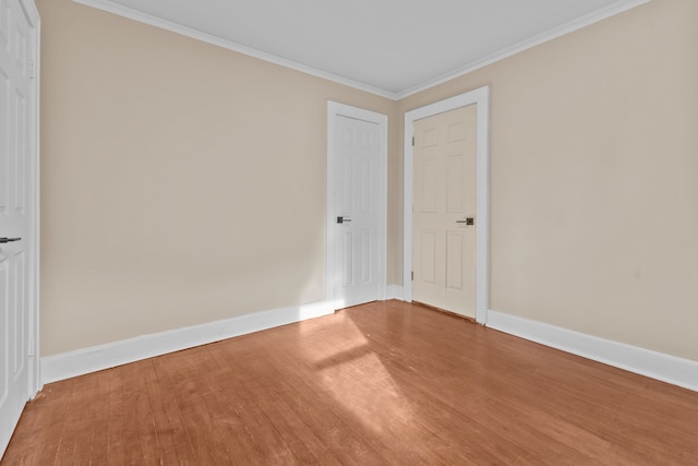 spare room featuring hardwood / wood-style flooring and ornamental molding