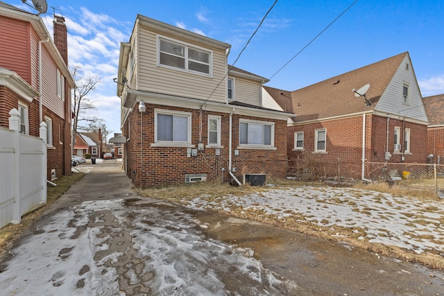 snow covered house featuring central AC