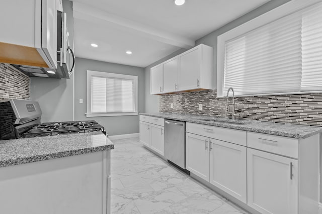 kitchen featuring sink, stainless steel appliances, light stone counters, white cabinets, and decorative backsplash