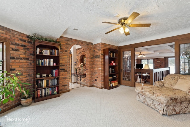 interior space with ceiling fan, light colored carpet, and a textured ceiling