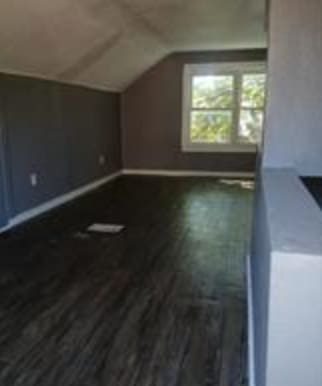 additional living space featuring hardwood / wood-style flooring and vaulted ceiling