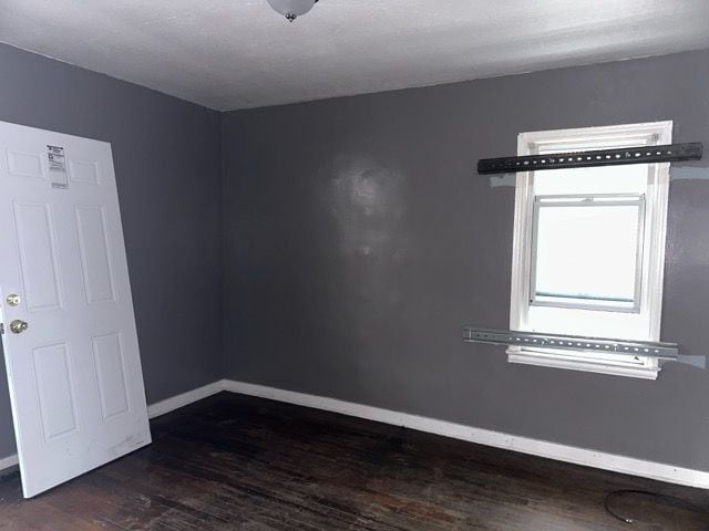 unfurnished room featuring dark hardwood / wood-style floors