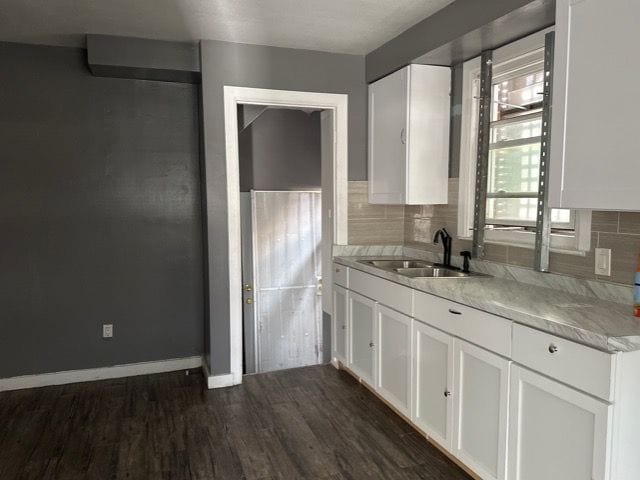 kitchen with backsplash, dark hardwood / wood-style floors, sink, and white cabinets