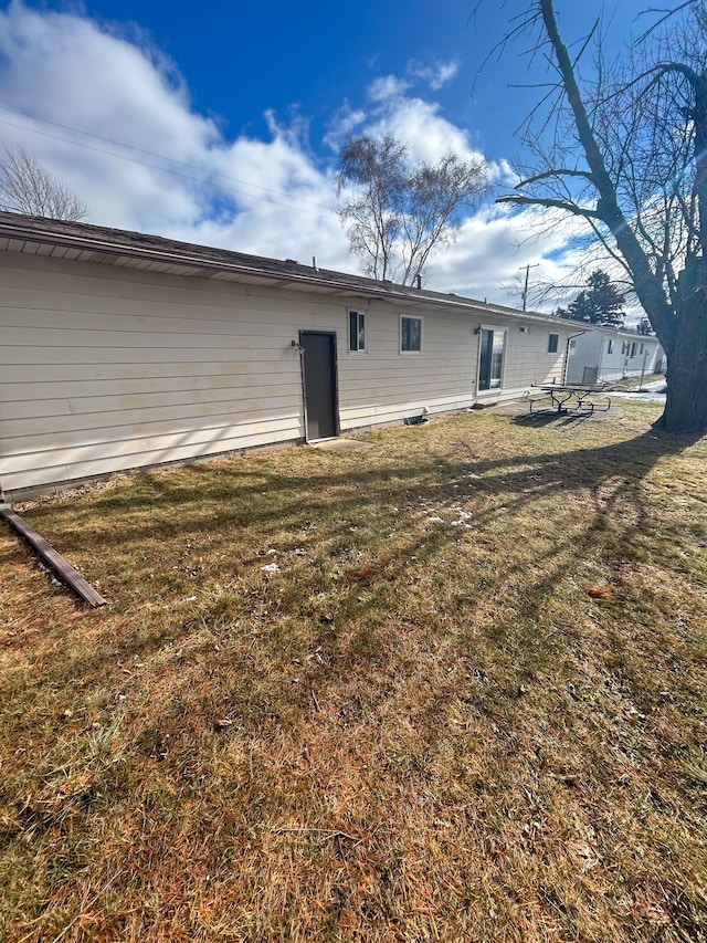 back of property featuring a lawn