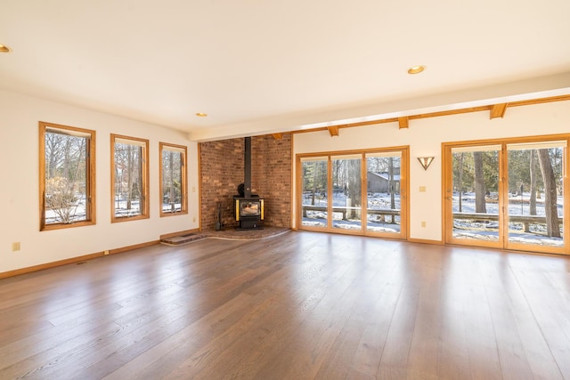 unfurnished living room with hardwood / wood-style flooring and a wood stove