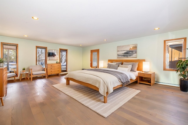 bedroom with a baseboard radiator and hardwood / wood-style floors