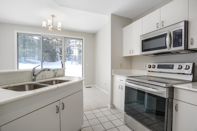 kitchen with pendant lighting, sink, stainless steel appliances, white cabinets, and a chandelier