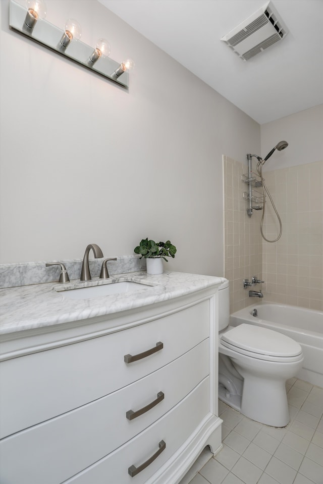 full bathroom with tiled shower / bath, vanity, toilet, and tile patterned flooring