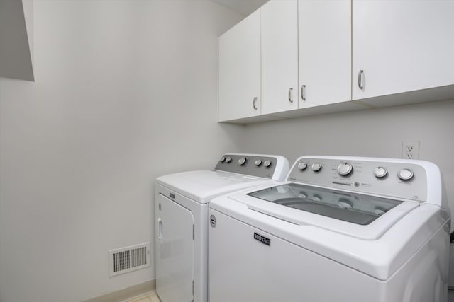 washroom featuring cabinets and washing machine and dryer