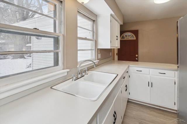 kitchen with white cabinetry, light hardwood / wood-style floors, and sink