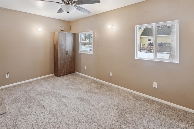 unfurnished bedroom with multiple windows, carpet flooring, and ceiling fan