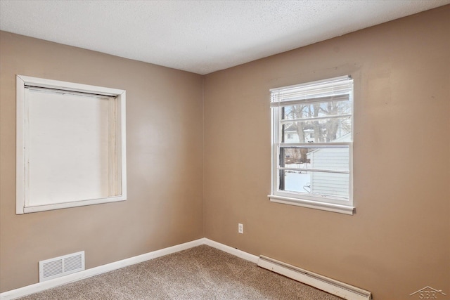 carpeted empty room with a baseboard radiator and a textured ceiling