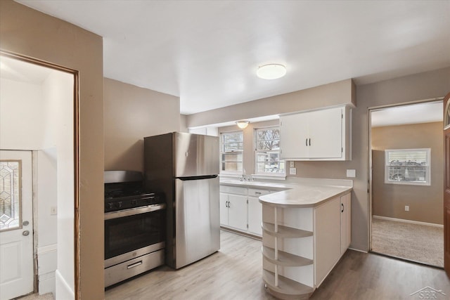 kitchen featuring white cabinetry, sink, light hardwood / wood-style flooring, and appliances with stainless steel finishes