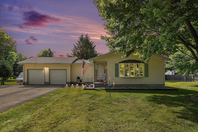 ranch-style home featuring a yard and a garage