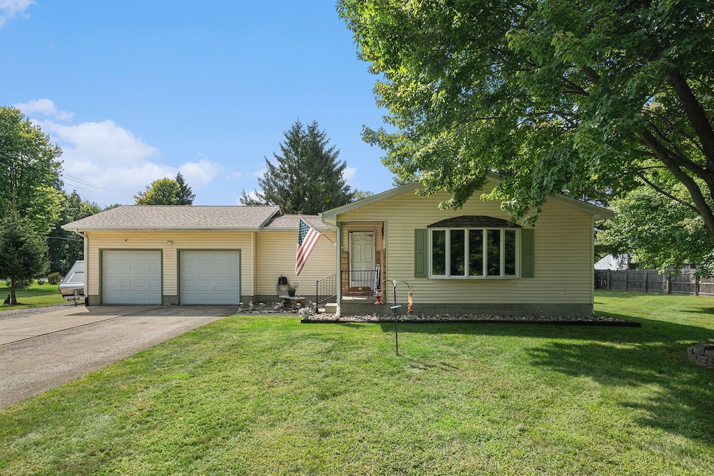 single story home featuring a garage and a front lawn