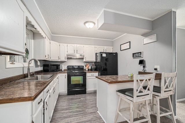 kitchen with a breakfast bar, sink, white cabinets, ornamental molding, and black appliances