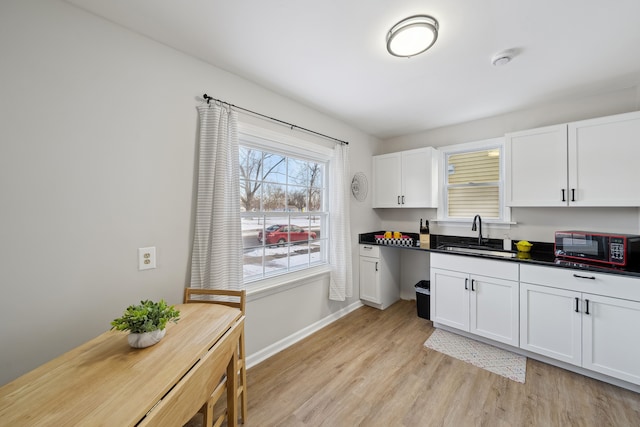 kitchen featuring white cabinetry, sink, and light hardwood / wood-style floors